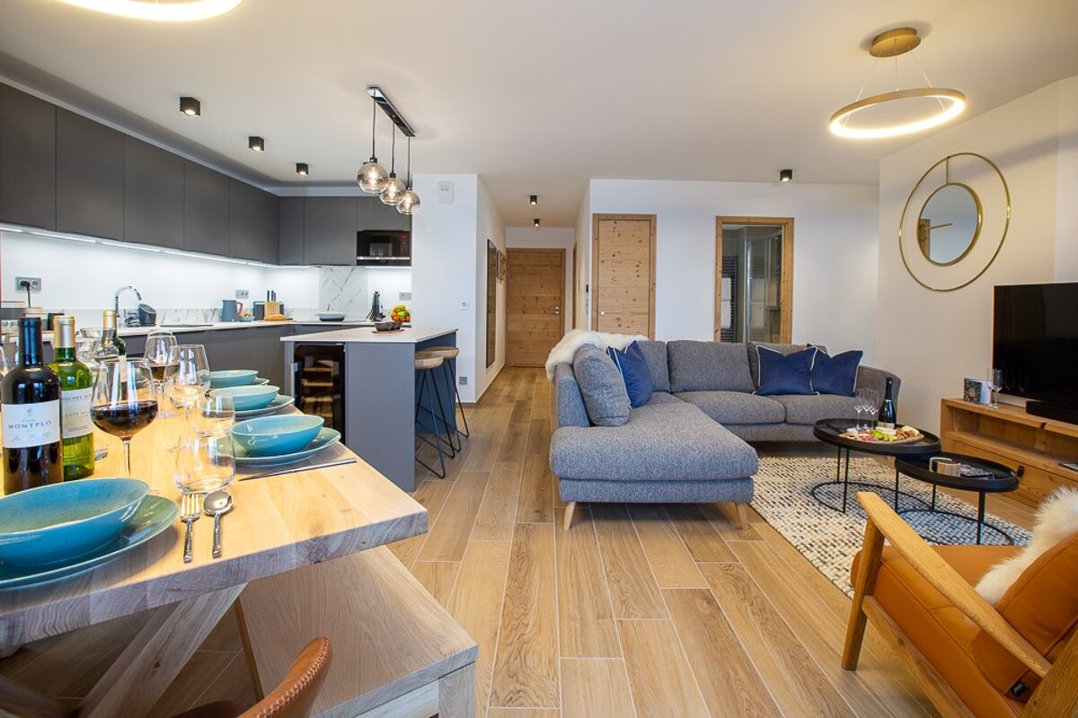 A living room with a couch and a table with a bottle of chateau on it