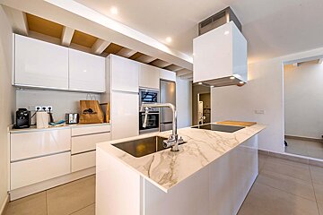 A kitchen with white cabinets and a bag that says adidas on it