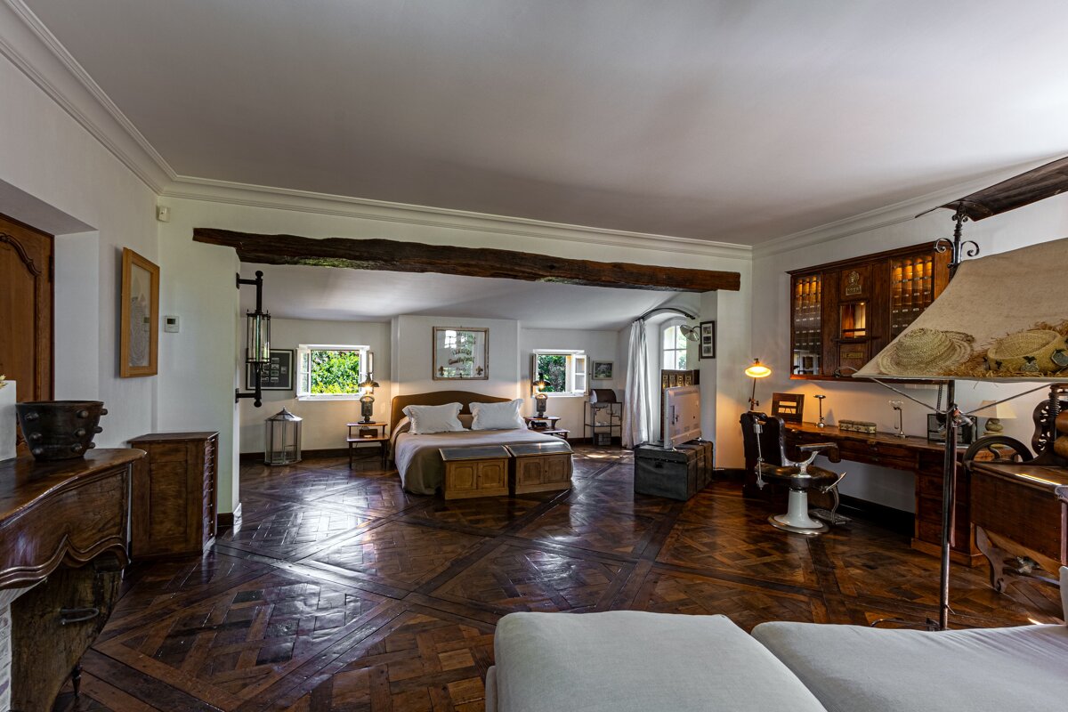 A bedroom with a wooden floor and a bed