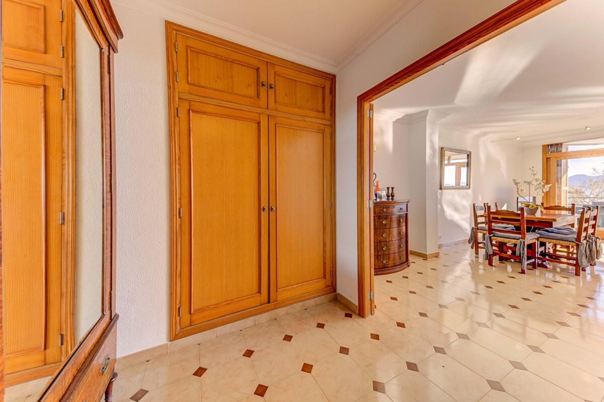 A hallway leading to a dining room with a table and chairs