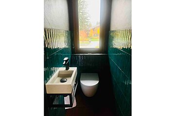 A bathroom with a sink and toilet and a window