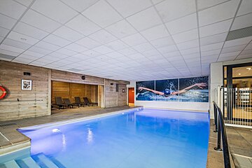 An indoor swimming pool with a picture of a swimmer on the wall