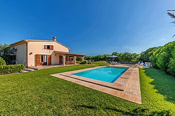 A house with a large swimming pool in front of it