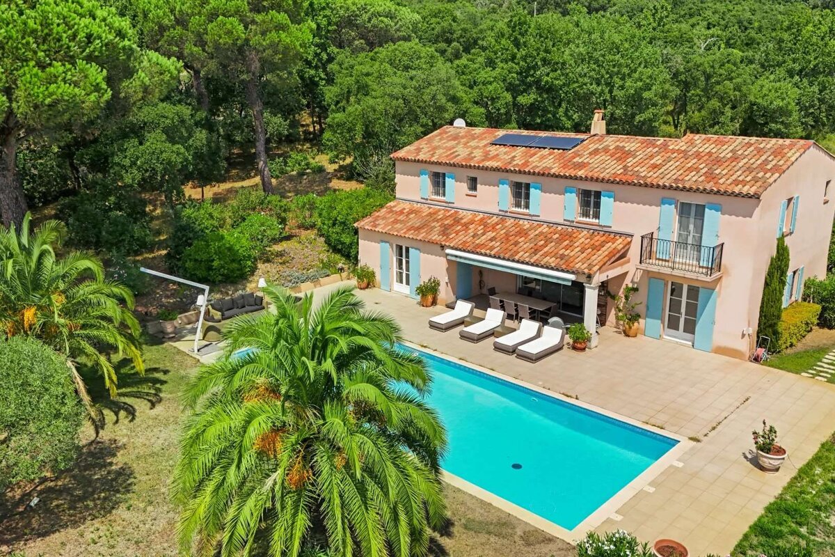 A large house with a swimming pool in front of it