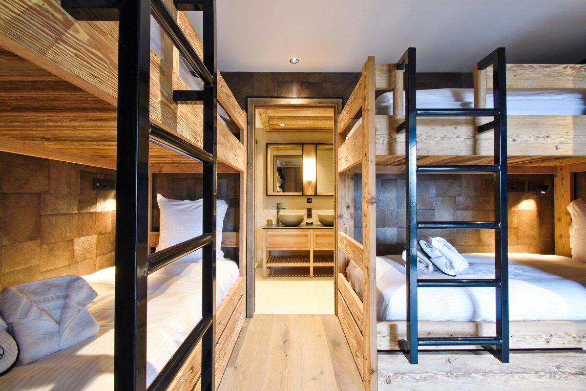 A room with bunk beds and a bathroom with a sink