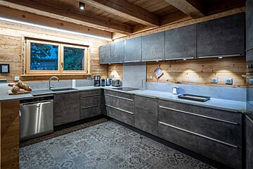 A kitchen with stainless steel appliances and gray cabinets
