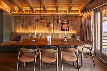 A dining room with a wooden table and chairs