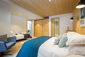 A bedroom with two beds and a chair