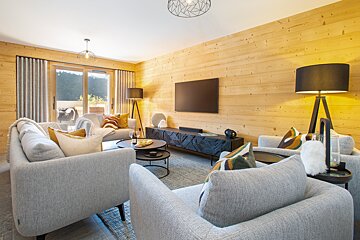 A living room with wood paneling and a flat screen tv