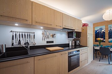 A kitchen with wooden cabinets and black counter tops