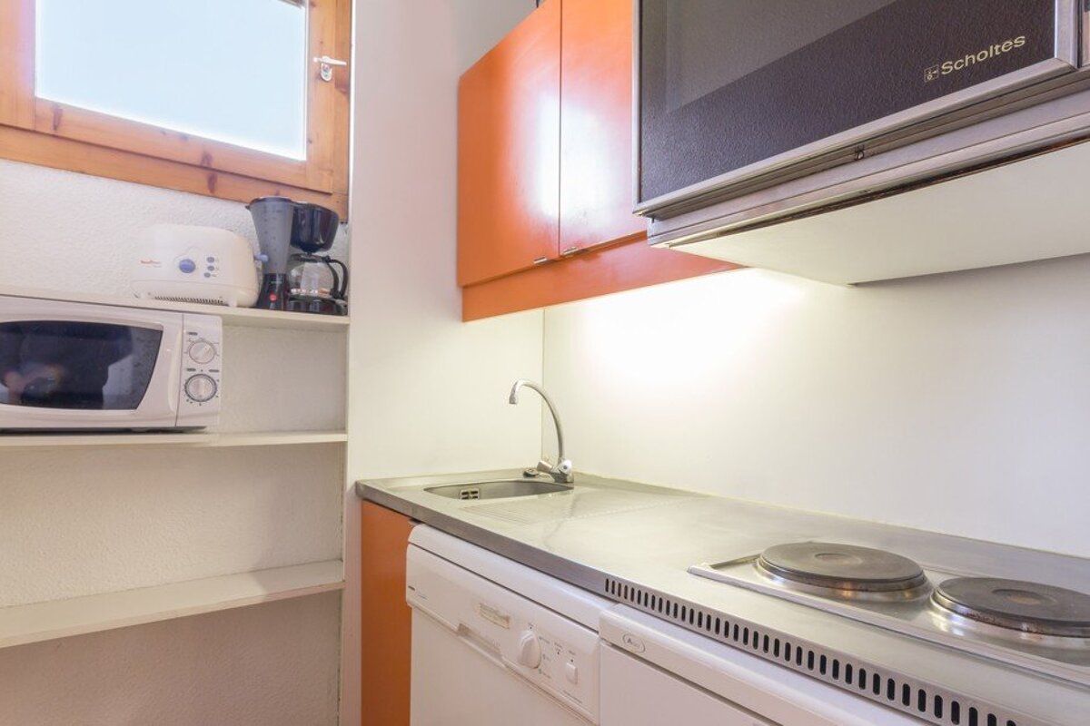 A kitchen with a schottes microwave above the stove