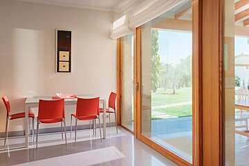 A dining room with a table and chairs and a sliding glass door