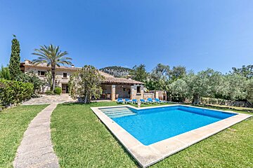 A large swimming pool in front of a house