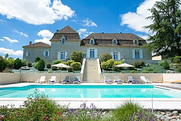 A large house with a swimming pool in front of it