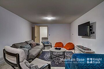 A living room with a couch and chairs and a knight frank logo on the wall