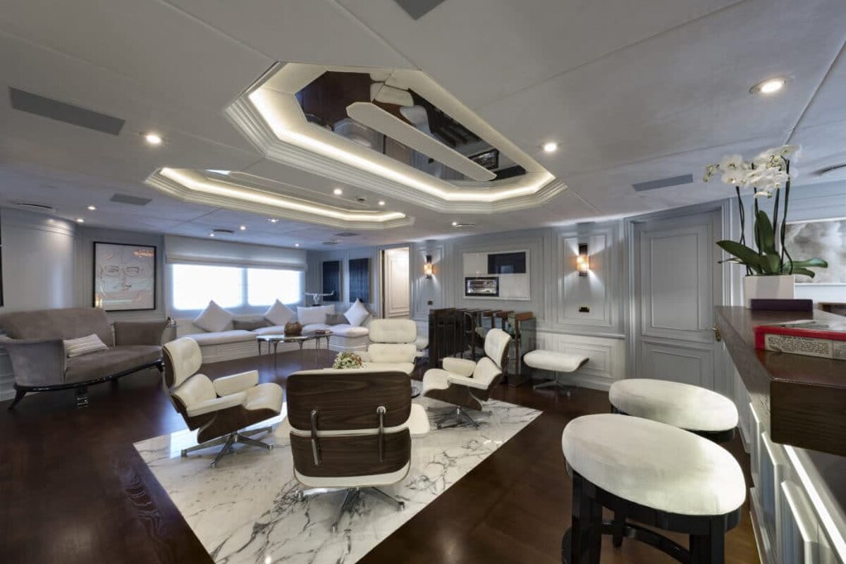 A living room with a couch and chairs and a mirrored ceiling
