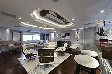 A living room with a couch and chairs and a mirrored ceiling