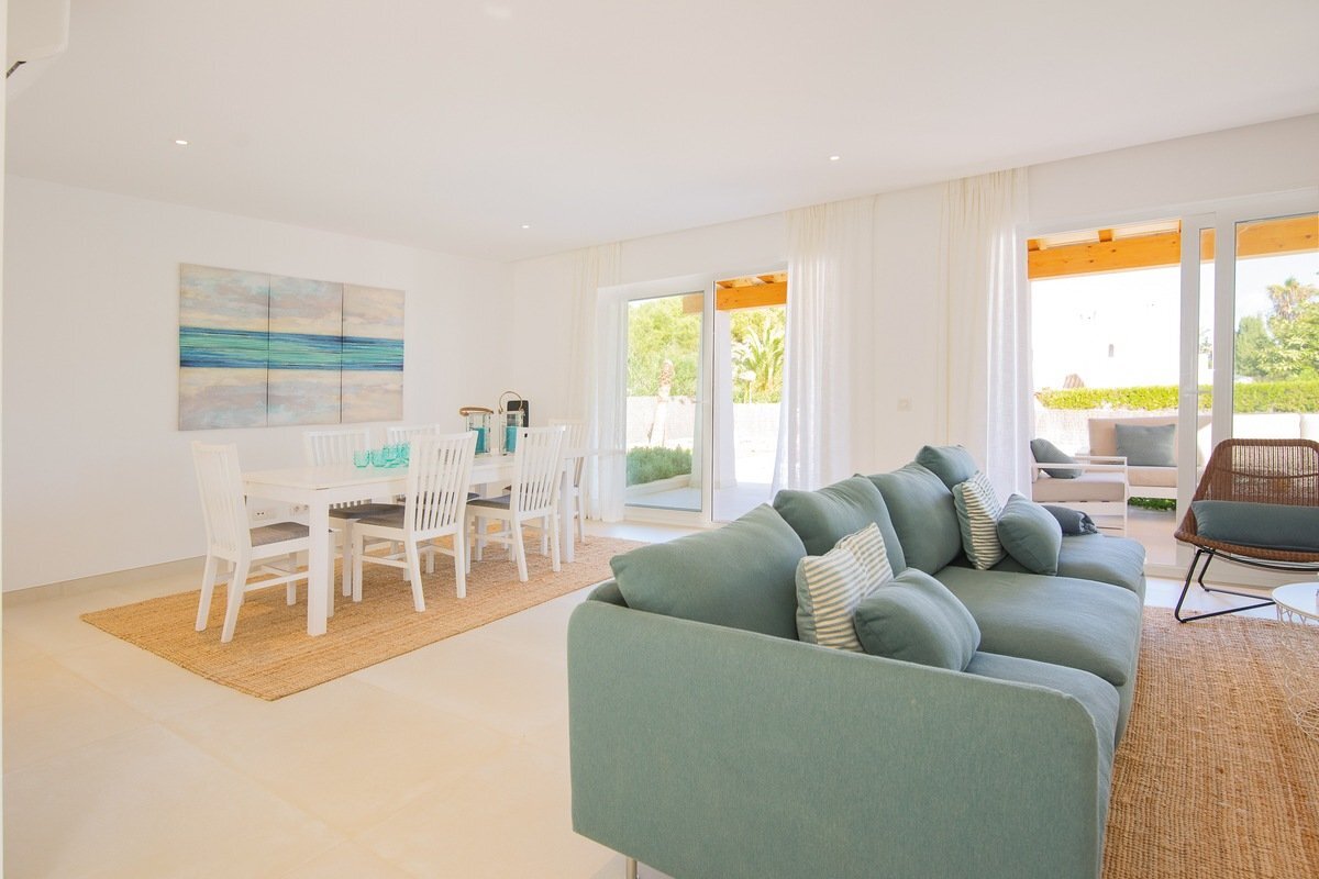 A living room with a blue couch and white chairs