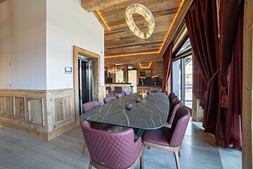 A dining room with a large table and chairs