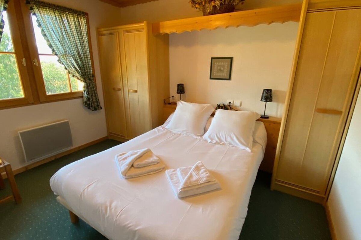 A bedroom with a bed and a picture on the wall that says happy