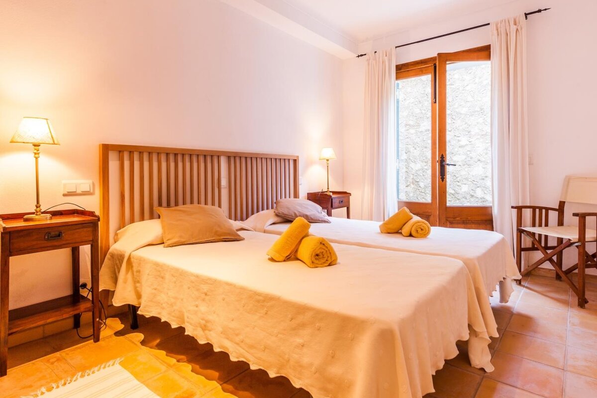 A bedroom with two beds and a chair