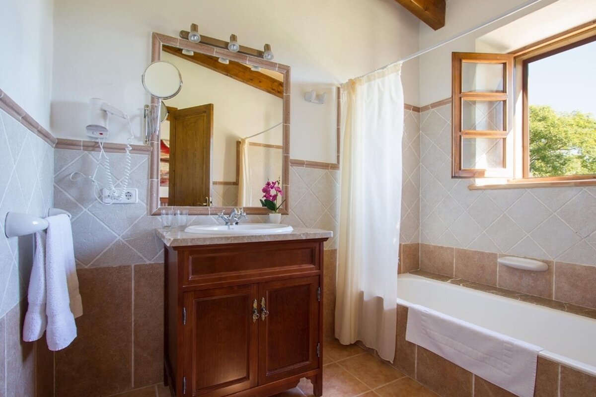 A bathroom with a sink a mirror and a window