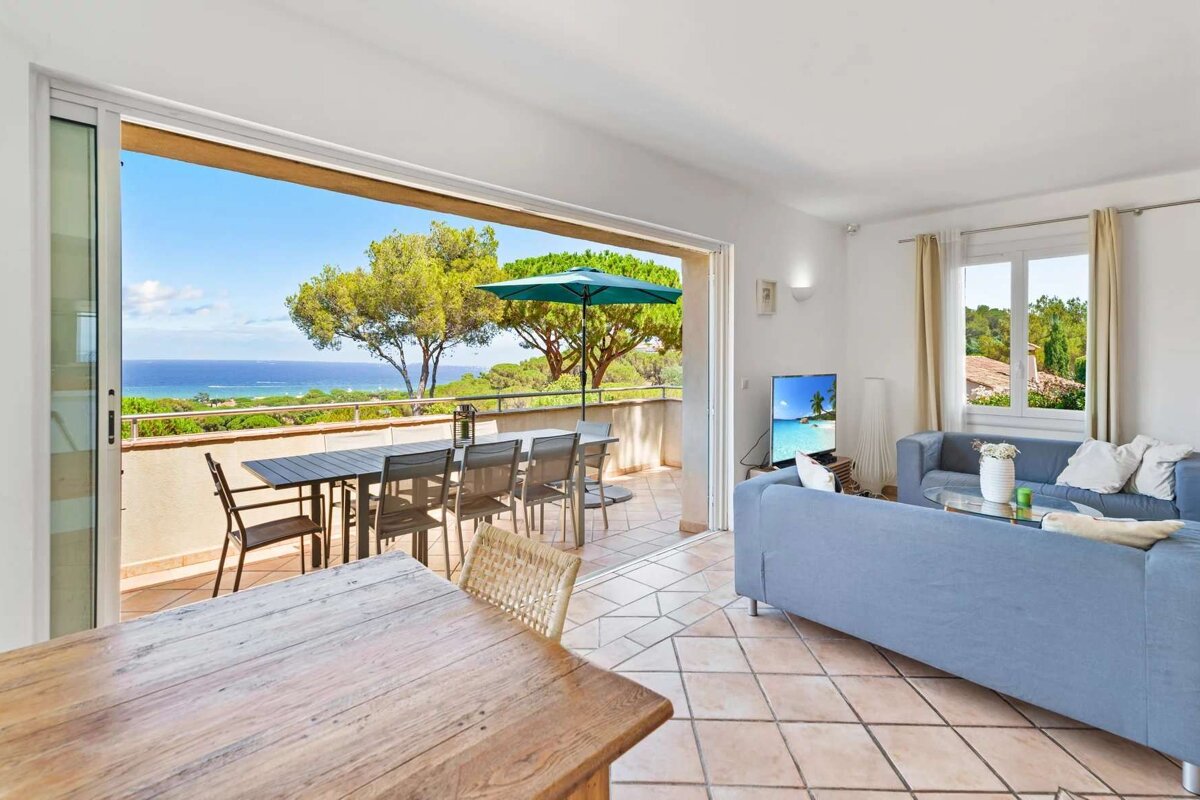 A living room with a blue couch and a view of the ocean