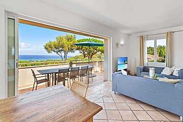 A living room with a blue couch and a view of the ocean