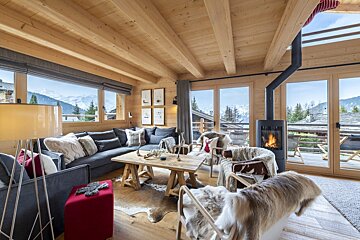 A living room with a fireplace and a view of the mountains