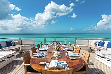 A large dining table with a view of the ocean