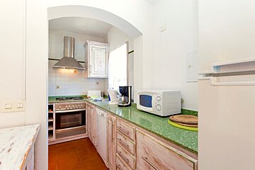 A kitchen with white cabinets and green counter tops