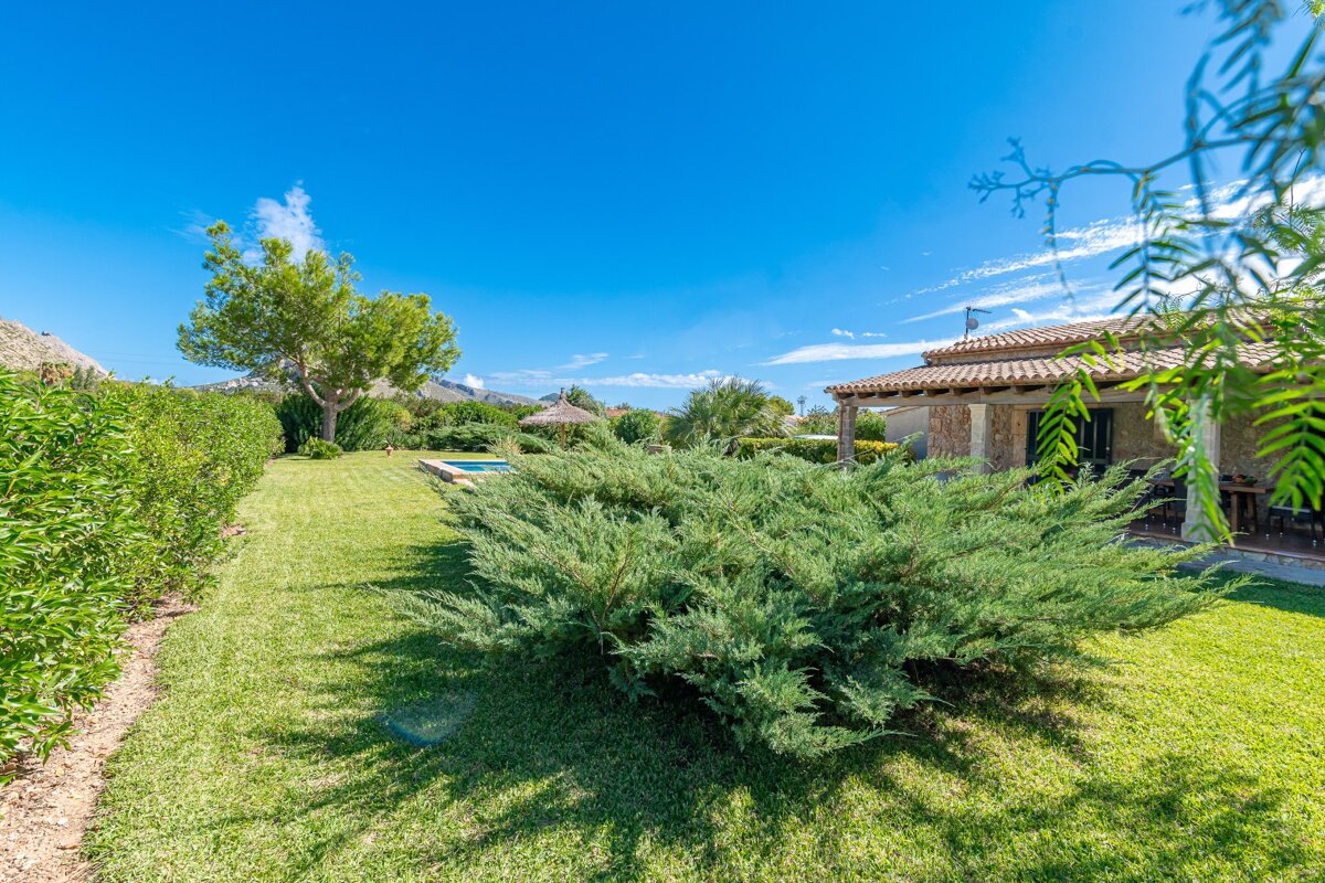 A lush green yard with a house in the background