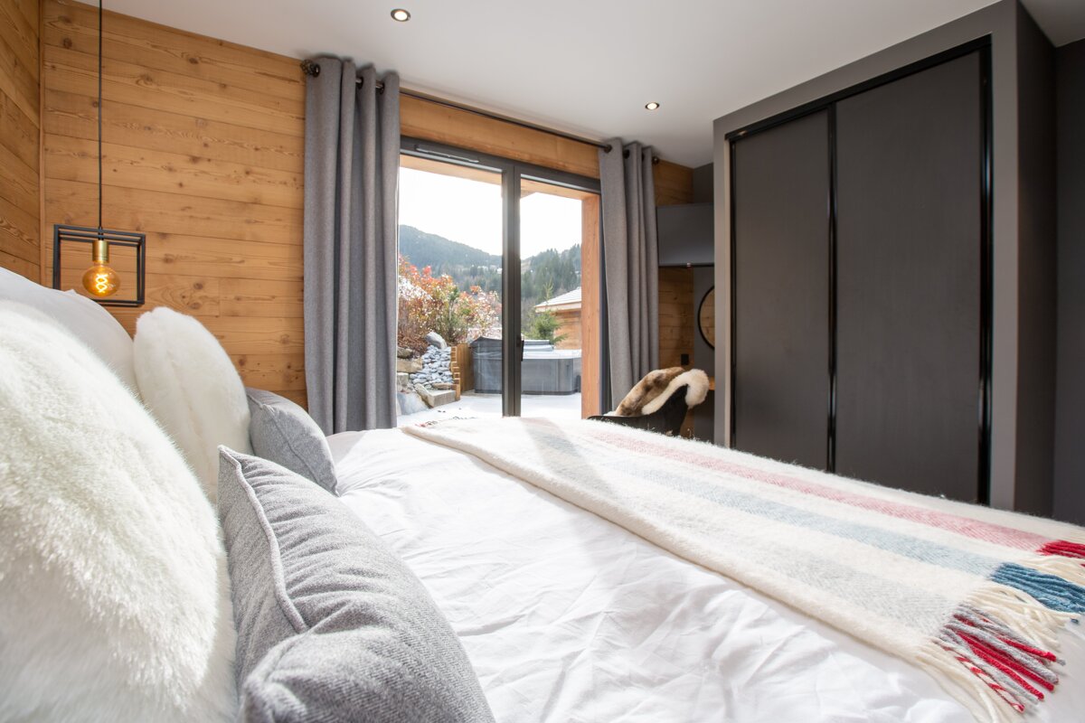 A bedroom with a large bed and a sliding glass door
