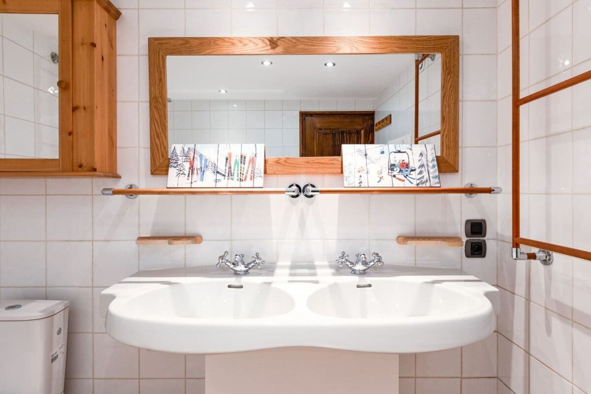 A bathroom with two sinks and a large mirror