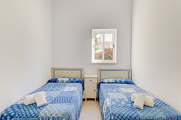 A bedroom with two beds and a window