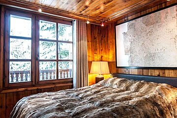 A bedroom with a fur blanket on the bed