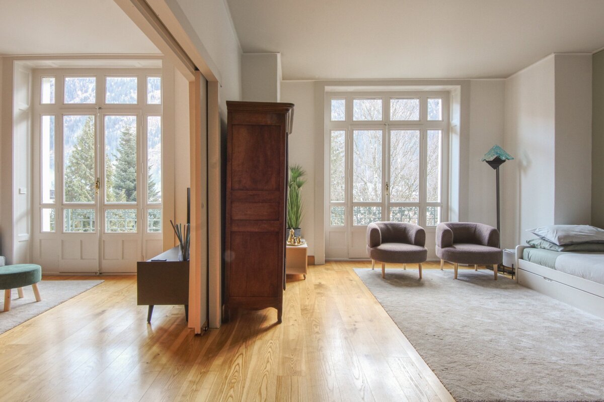 A living room with two chairs and a dresser