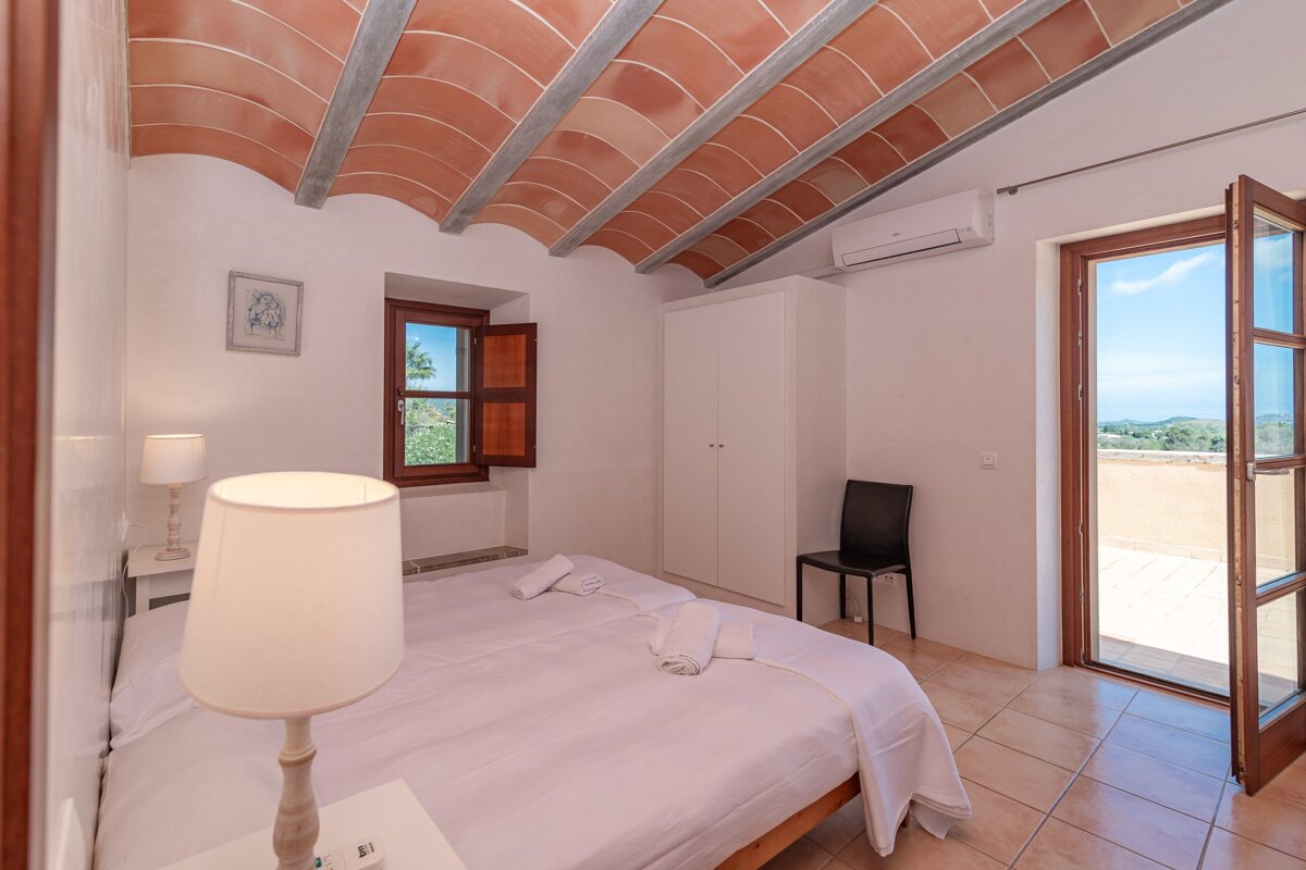 A bedroom with a bed a lamp and a window