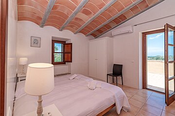 A bedroom with a bed a lamp and a window