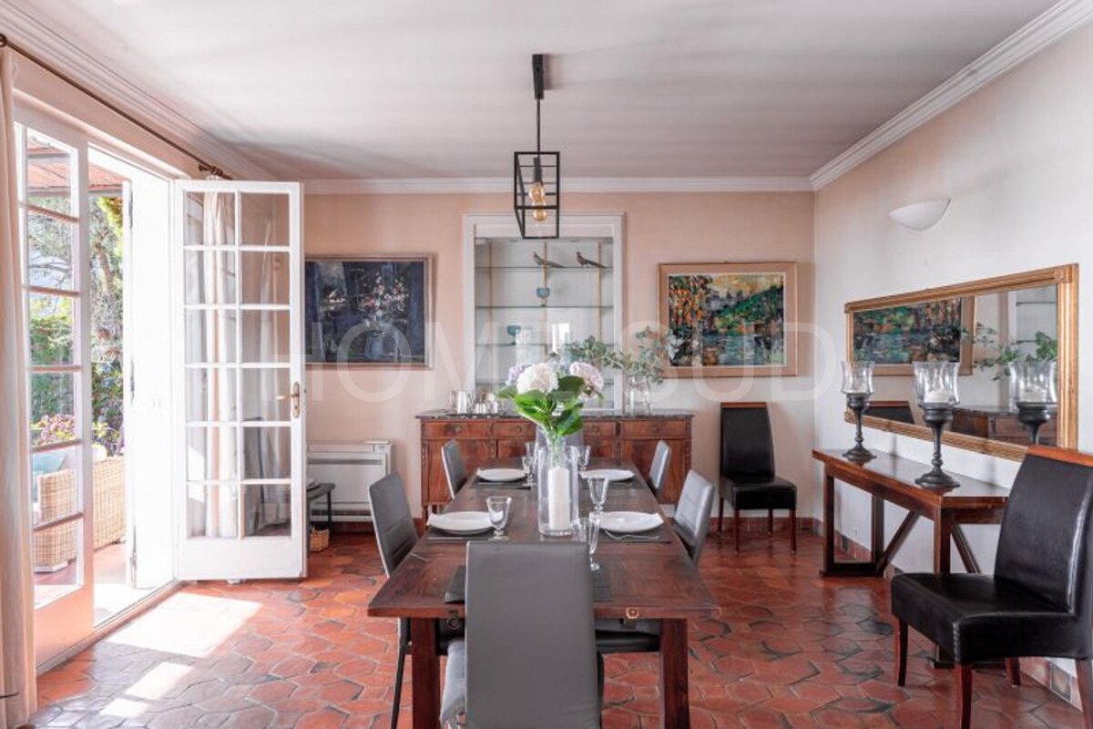 A dining room with a large wooden table and chairs