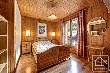 A bedroom with a bed and a mirror and a sign that says alpine property
