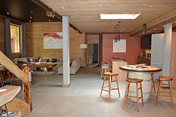 A living room with a barrel table and stools