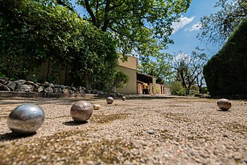 A bunch of balls are on the ground in front of a house