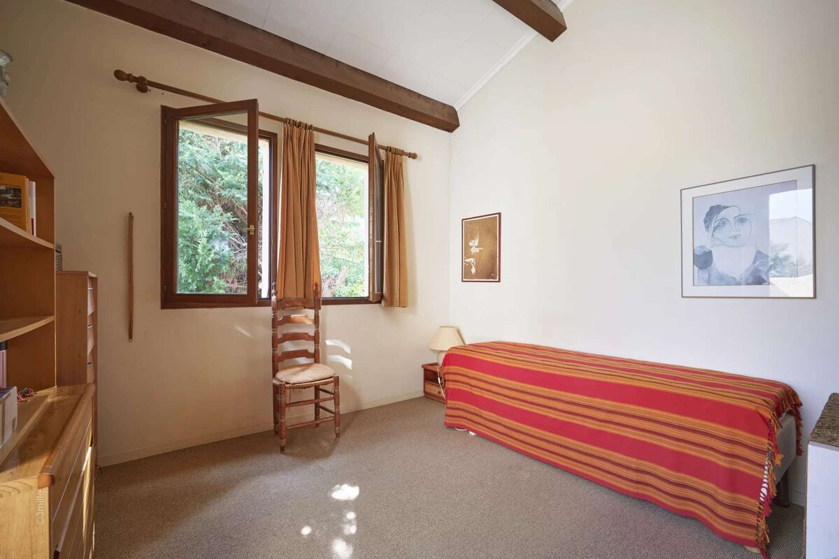 A bedroom with a single bed and a picture on the wall