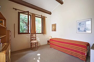 A bedroom with a single bed and a picture on the wall