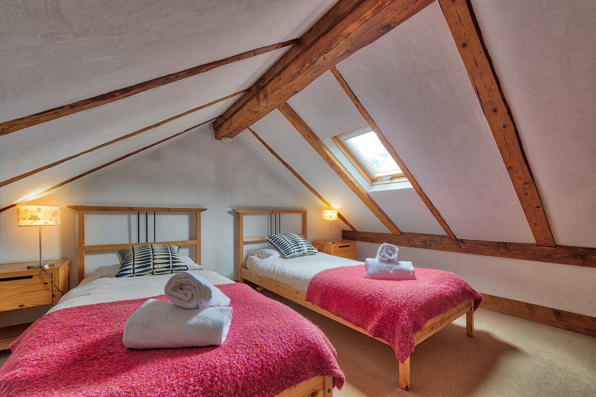 A bedroom with two twin beds and a skylight