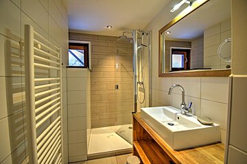 A bathroom with a sink and a walk in shower