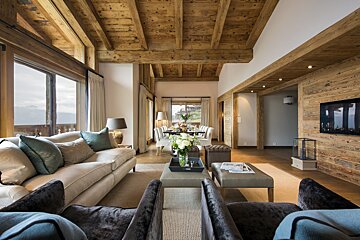 A living room with a couch and chairs and a flat screen tv