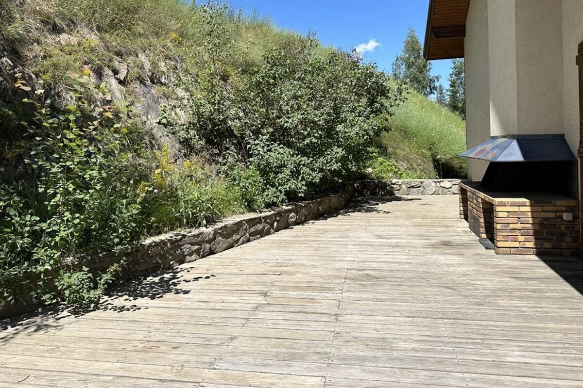 A wooden deck with a brick fireplace in the background