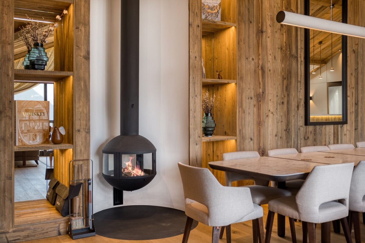 A dining room with a table and chairs and a fireplace
